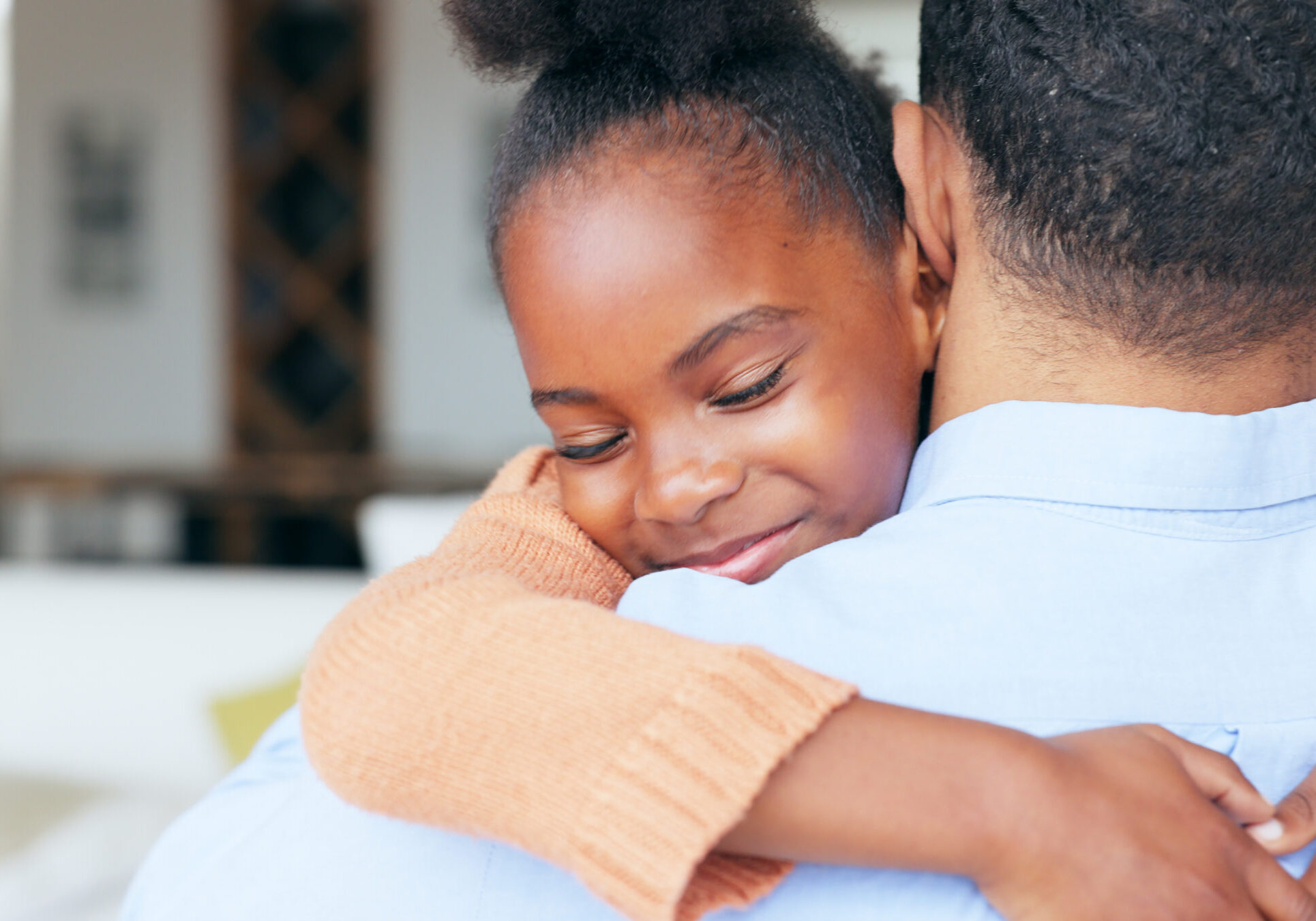 Girl, father and hug in closeup, back and family home with welcome, reunion and smile with love in living room. African daughter, dad and embrace with care, happy and bonding in lounge at apartment.